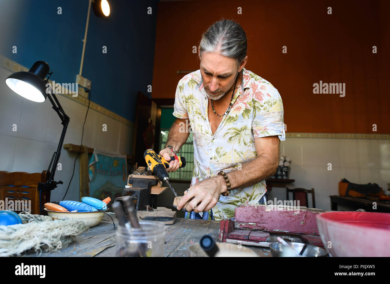 (181023) - HAIKOU, Oktober 23, 2018 (Xinhua) - kanadische Craig Anderson arbeitet im Eco - Nachhaltigkeit Service Center der West Insel in Sanya, South China Hainan Provinz, Sept. 19, 2018. Anderson kam im Februar an der West Island, bewohnt von rund 4.000 Personen. Einheimische angesehen Anderson als eine Art Schnitzeljagd, als er das erste Mal hier war, als er um den Strand fast jeden Tag wanderte, Treibholz, Plastikflaschen, zerbrochene Gläser, und rostige Stück Eisen. Die Zeit verging, und die Einheimischen klar, dass Anderson ist ein Künstler, der sich für den Umweltschutz art Design widmet. Er Stockfoto