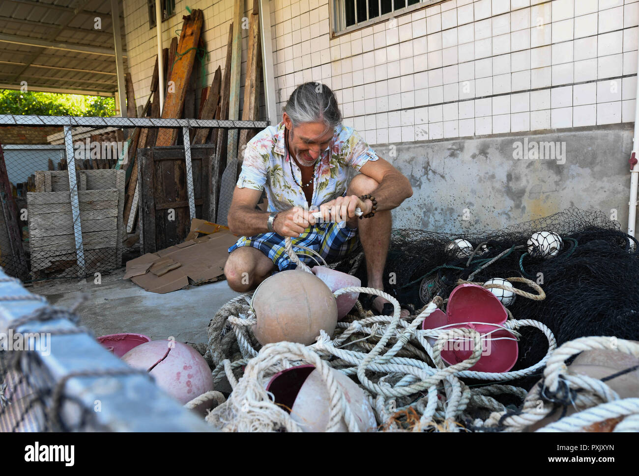 (181023) - HAIKOU, Oktober 23, 2018 (Xinhua) - kanadische Craig Anderson ordnet Wertstoffe im Eco - Nachhaltigkeit Service Center der West Insel in Sanya, South China Hainan Provinz, Sept. 19, 2018. Anderson kam im Februar an der West Island, bewohnt von rund 4.000 Personen. Einheimische angesehen Anderson als eine Art Schnitzeljagd, als er das erste Mal hier war, als er um den Strand fast jeden Tag wanderte, Treibholz, Plastikflaschen, zerbrochene Gläser, und rostige Stück Eisen. Die Zeit verging, und die Einheimischen klar, dass Anderson ist ein Künstler, der sich in der Umgebung p widmet. Stockfoto