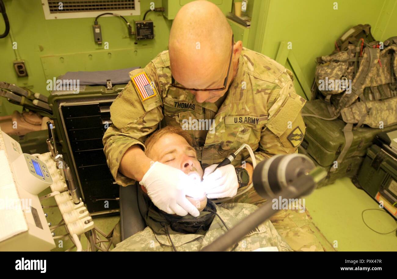 Oberstleutnant Blake Thomas, mit der Firma C, 106 Support Battalion, formen ein Komposit Füllung auf Zahn am National Training Center, 1. Juni 2017 Ein Soldat. "Charlie Med" bietet die gleiche Qualität der Pflege in einem Feld Umwelt als lokale Gesundheit Klinik. (Mississippi Stockfoto