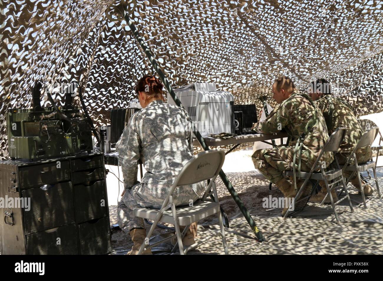 Soldaten aus der Konzernzentrale, 150 Techniker Bataillon, Mississippi Army National Guard, erhalten Informationen über das Radio, die darauf hinweist, dass ein Fahrzeug mit vier Personen sind an der Einlasskontrolle. Hauptsitz tactical Operations Center Personal Protokolle überprüfen, um sicherzustellen, dass Sie erwartet die Besucher, bevor Sie Mitteilungen senden für das Fahrzeug zu betreten, 1. Juni 2017, in Fort Irwin, Kalifornien. (Mississippi Stockfoto