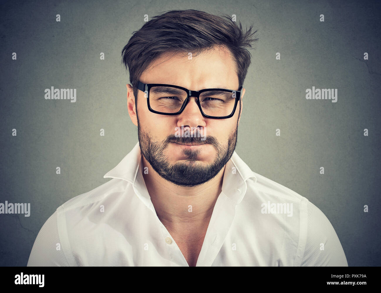 Portrait von bärtigen Mann in Gläsern und weißes Hemd suchen super und Negativ an Kamera genervt Stockfoto