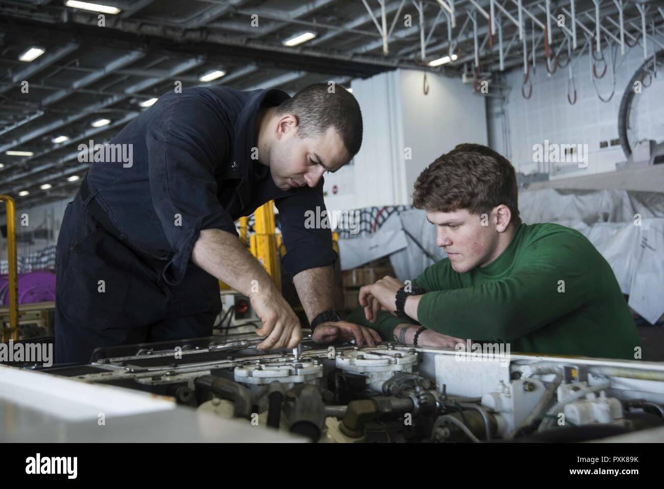 Atlantik (4. Juni 2017) Aviation Support Equipment Techniker 3. Klasse Ryan Rios, links, von Fresno, Kalifornien, und Aviation Support Equipment Techniker Airman Zane Bradbury, von Charlestown, W. Virginia, Wartung Durchführen einer Spotting dolly im Hangar Bucht der Flugzeugträger USS Dwight D. Eisenhower (CVN 69) (IKE). Ike ist derzeit Flugzeugträger Qualifikationen während der lebenserhaltung Phase des optimierten Flotte Notfallplan (OFRP). Stockfoto