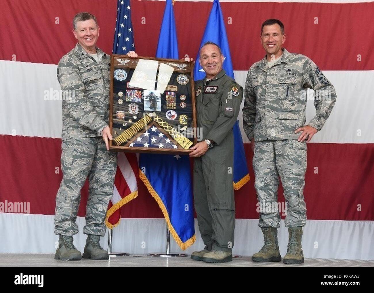 Colonel Bryan Cook, 944th Fighter Wing Commander, und Chief Master Sgt. James Nudd, 944 FW interim Befehl Chief, Gegenwart (Ret.) Oberst Kurt Gallegos, 944 FW ehemaliger Kommandant, mit einem Schatten, 3. Juni im Rahmen einer Feierstunde in den Ruhestand Luke Air Force Base, Arizona. Stockfoto