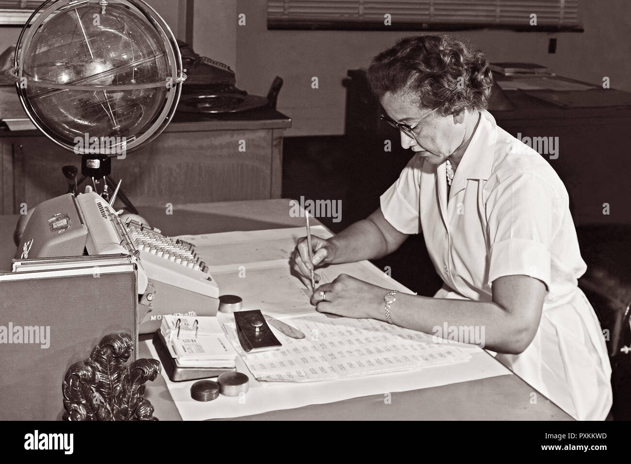 Katherine Johnson, NASA Forschung Mathematiker, an ihrem Schreibtisch bei der NASA Langley Research Center mit einer Kugel, oder "himmlischen Training Device", 1962. Stockfoto