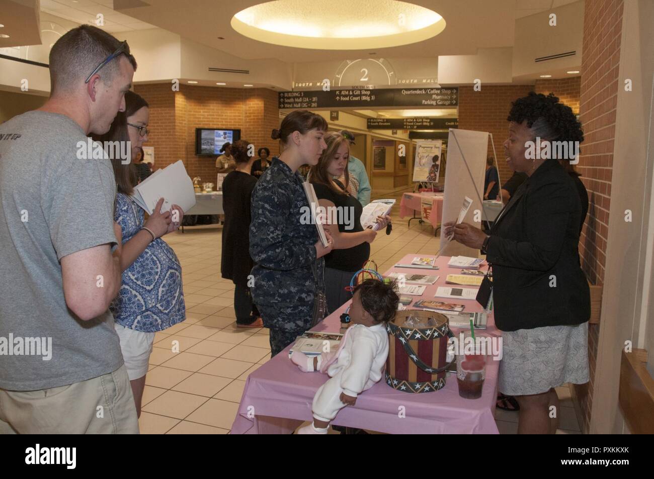 Portsmouth, Virginia (9. Juni 2017) Racquel Pitts, um eine neue übergeordnete Support home Besucher mit der Flotte und Family Support Center, rechts, erklärt die Programme durch FFSC für schwangere Begünstigten und neue Eltern während der Schwangerschaft Fair an der Portsmouth Naval Medical Center zur Verfügung. Die Women's Health Clinic förderte das fair, dass Informationen über eine Vielzahl der Schwangerschaft - verwandte Themen, wie Ernährung, Bewegung, fetale Entwicklung, Geburt und Stillzeit angeboten. Stockfoto