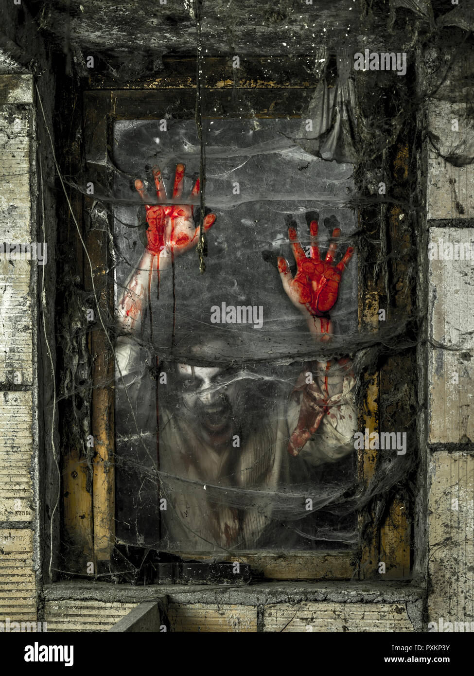 Foto eines hungrigen Zombies starrt dich durch ein schmutziges Fenster. Stockfoto