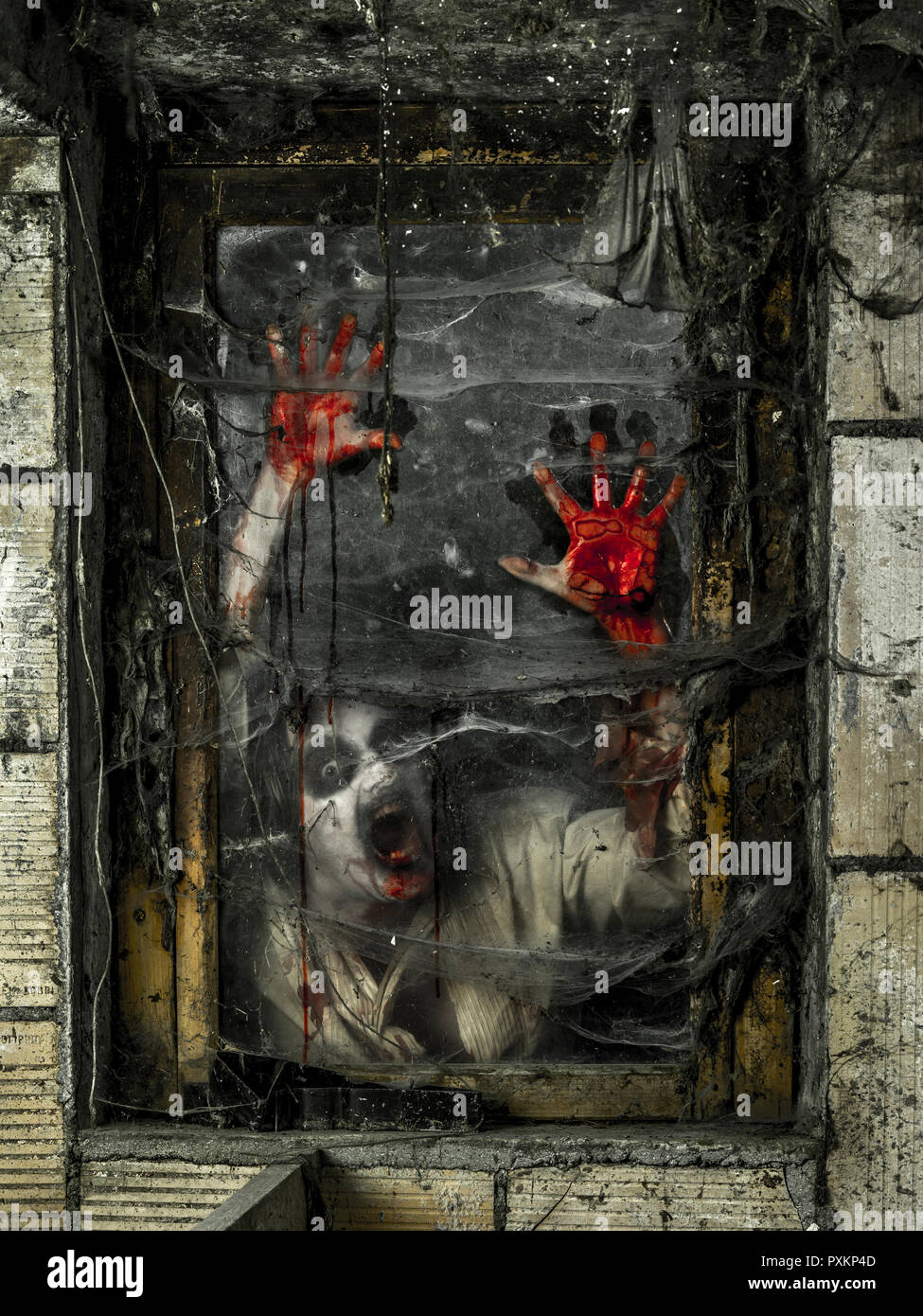 Foto eines hungrigen Zombies starrt dich durch ein schmutziges Fenster. Stockfoto