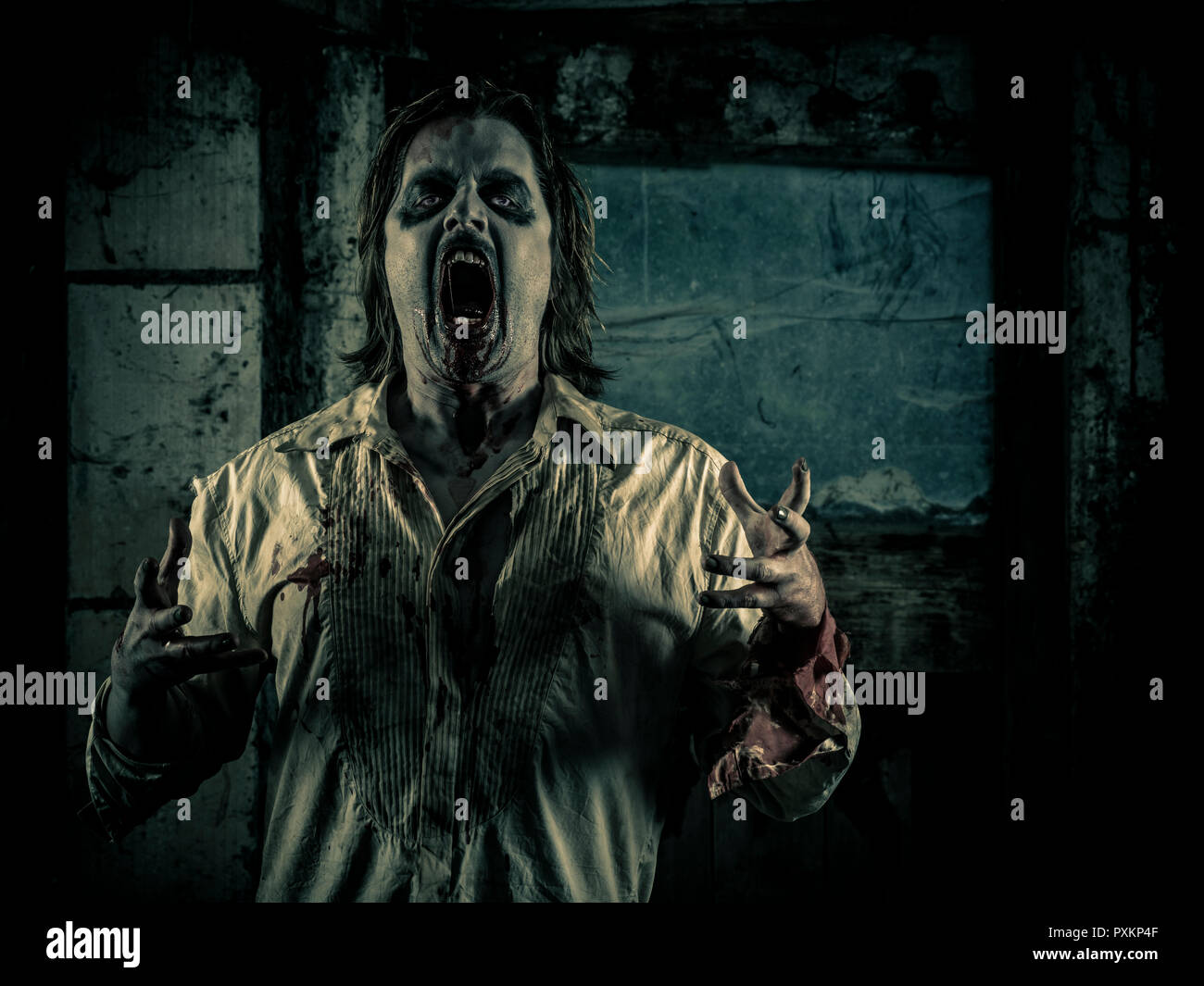 Foto von einem hungrigen Zombie starrte sie in einem dunklen unheimlichen Zimmer. Stockfoto