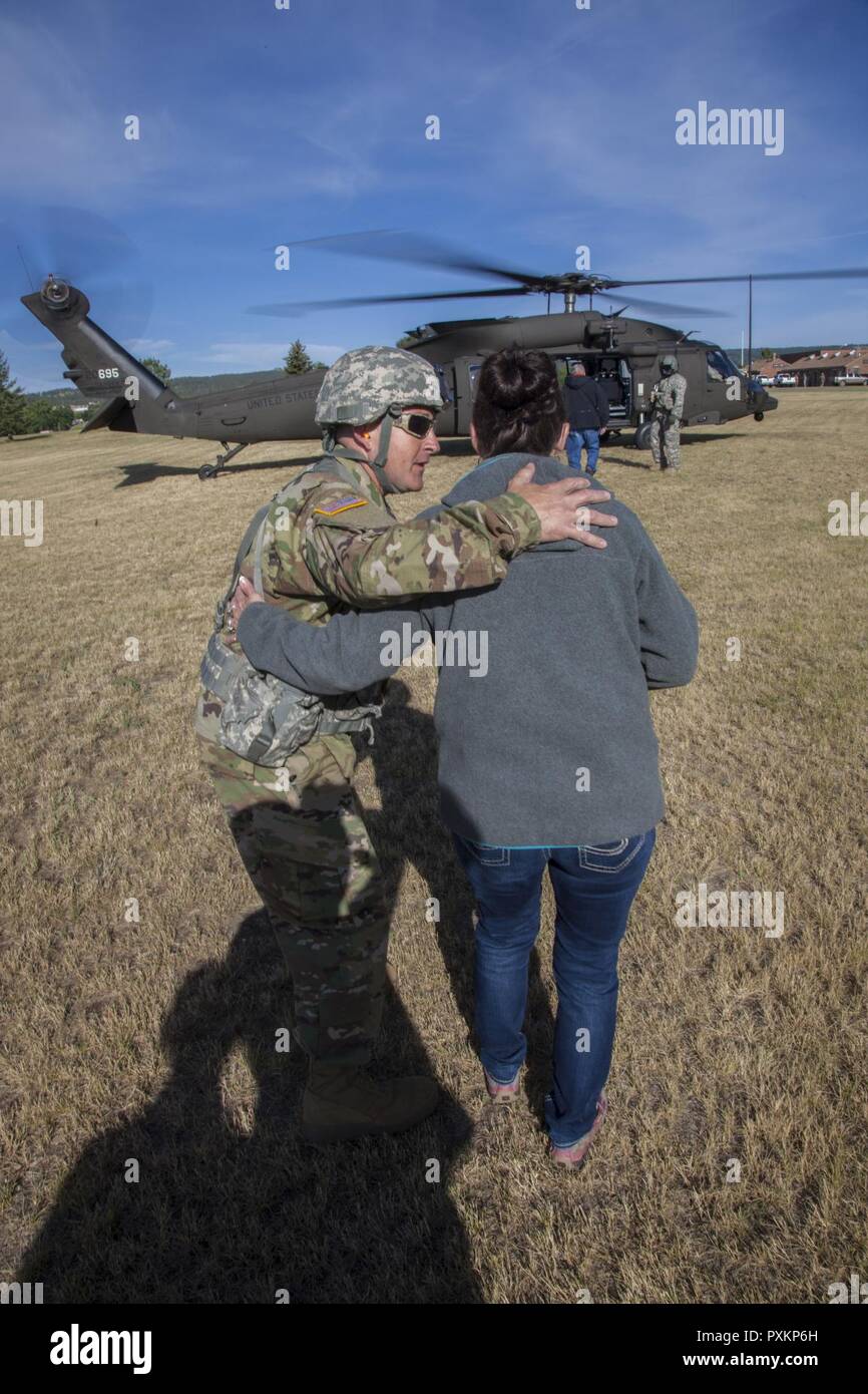 Us-Armee Master Sgt. Mike Dotson, Crew Chief mit Joint Force Head Quarters, South Dakota Army National Guard spricht mit Kim Vanneman Mitglied der South Dakota der militärischen Angelegenheiten, bevor ein HH-60 M MEDEVAC Black Hawk Verpflegung während der Goldenen Coyote Übung in Rapid City, S.D., 15. Juni 2017. Die goldenen Coyote Übung ist eine dreiphasige, Szenario-driven Übung in den Black Hills von South Dakota und Wyoming, mit dem Kommandanten auf der Mission wesentliche Anforderungen der Aufgabe, Krieger Aufgaben und Übungen zu konzentrieren. Stockfoto