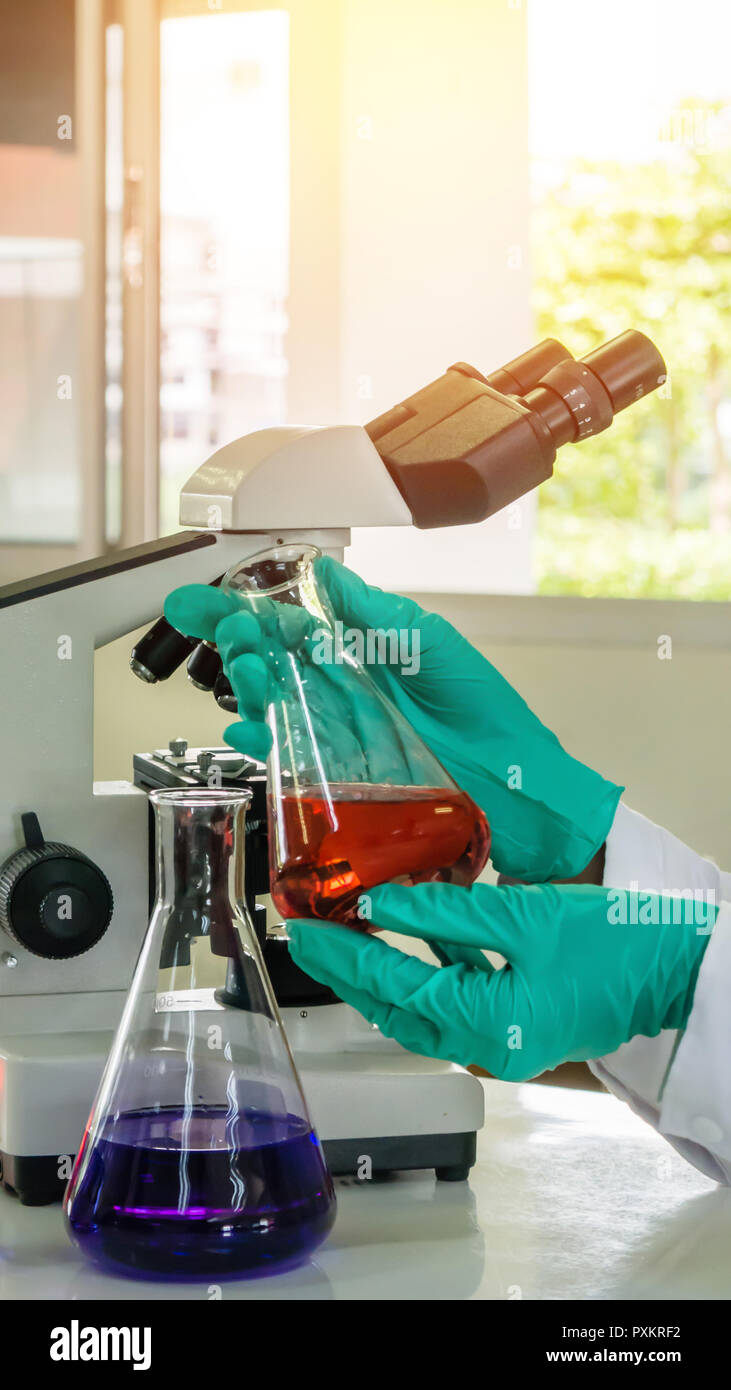 Labor Becher in der Analyst Hand in Kunststoff Handschuh Stockfoto