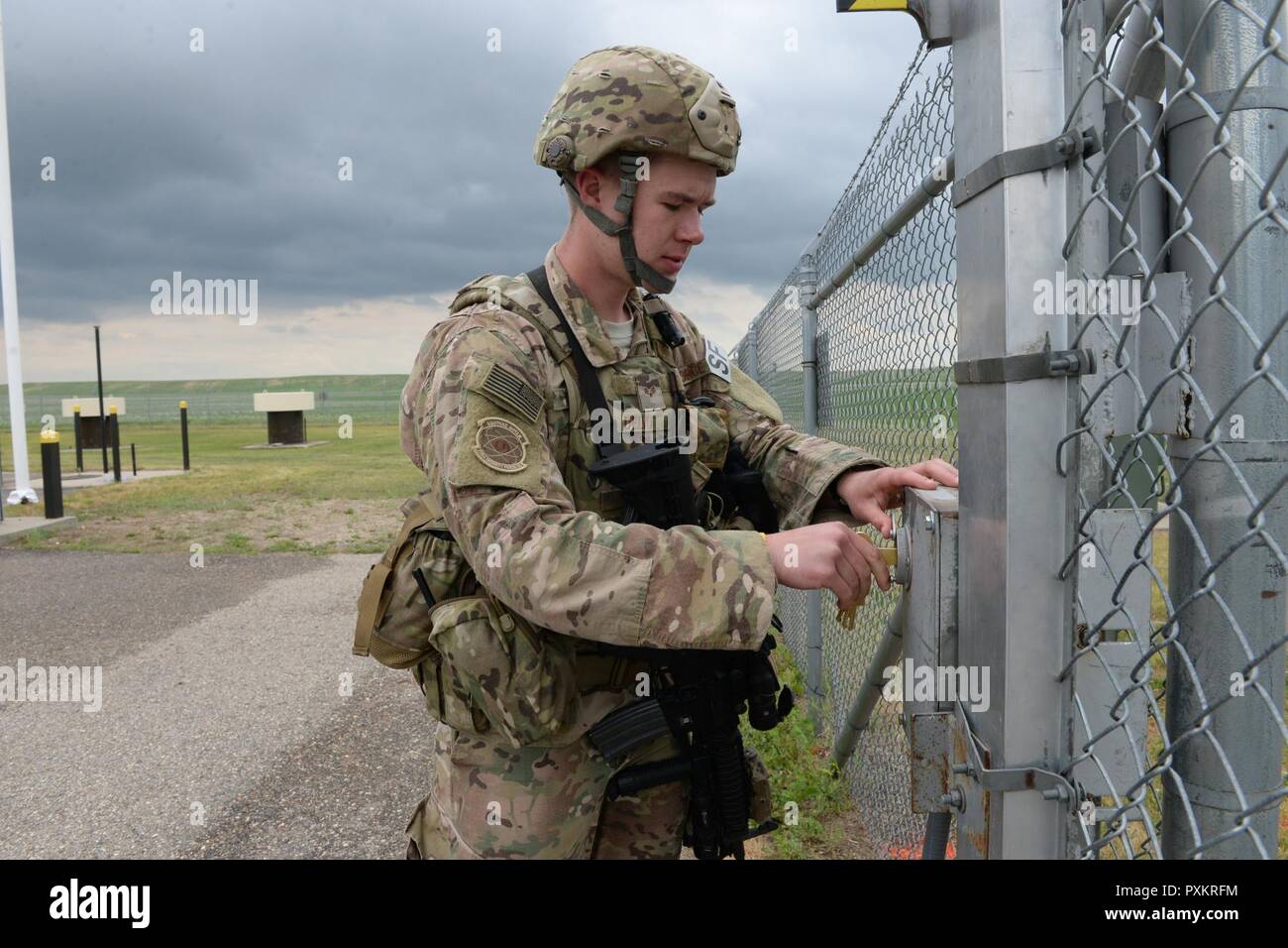 Us Air Force Senior Airman Andrew Delvo, der 219Th Security Forces Squadron, sperrt das Tor, als er eine Rakete alert in Minot Air Force Base Rakete Feld komplex betritt, in der Nähe von Minot, N.D., 15. Juni 2017. Er ist ein Mitglied der Texas Air National Guard Training und nahtlos, Seite an Seite mit der US Air Force Active Duty Sicherheitskräfte Mitglieder der 91st Rakete Wing, wie Sie halten die Sicherheitsstandards in der Rakete. Stockfoto