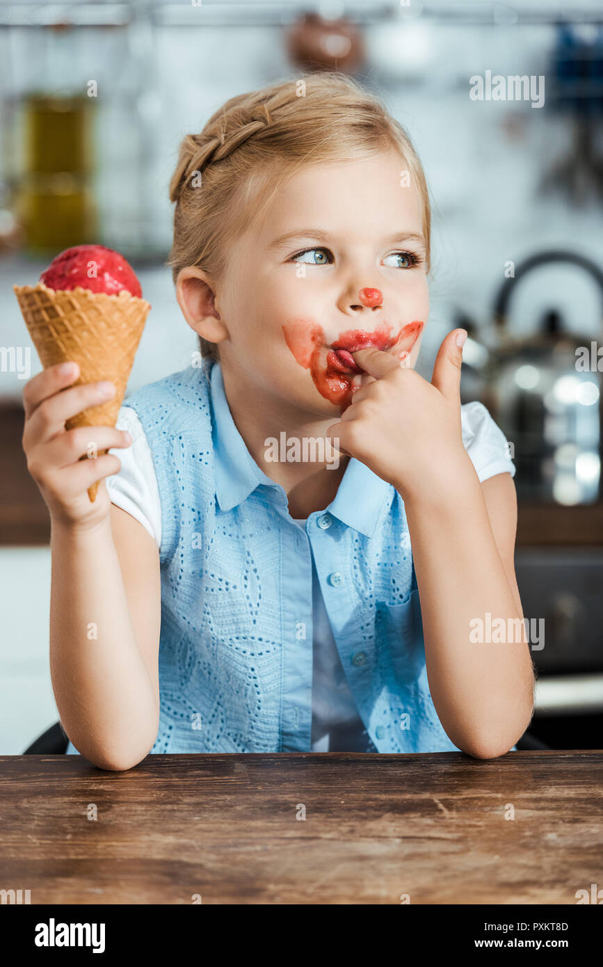 Adorable kleine Kind Süßigkeiten Speiseeis und lecken, Finger Stockfoto