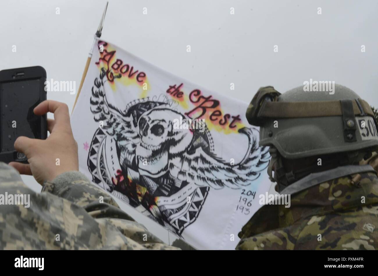 Soldaten ein Foto von der Air Assault guidon Flagge Nachdem Sie fertig Abseilen aus einem UH-60 Black Hawk Hubschrauber während des Air Assault Kurs am Lager Rilea in Warrenton, Virginia, 8. Juni 2017 statt. Abseilen ist einer der Tests service Mitglieder ausführen muss, um die Air Assault Badge ausgezeichnet zu werden. Der Kurs besteht aus körperlichem Training, ruck Märsche, Unterricht und praktische Übungen. Stockfoto