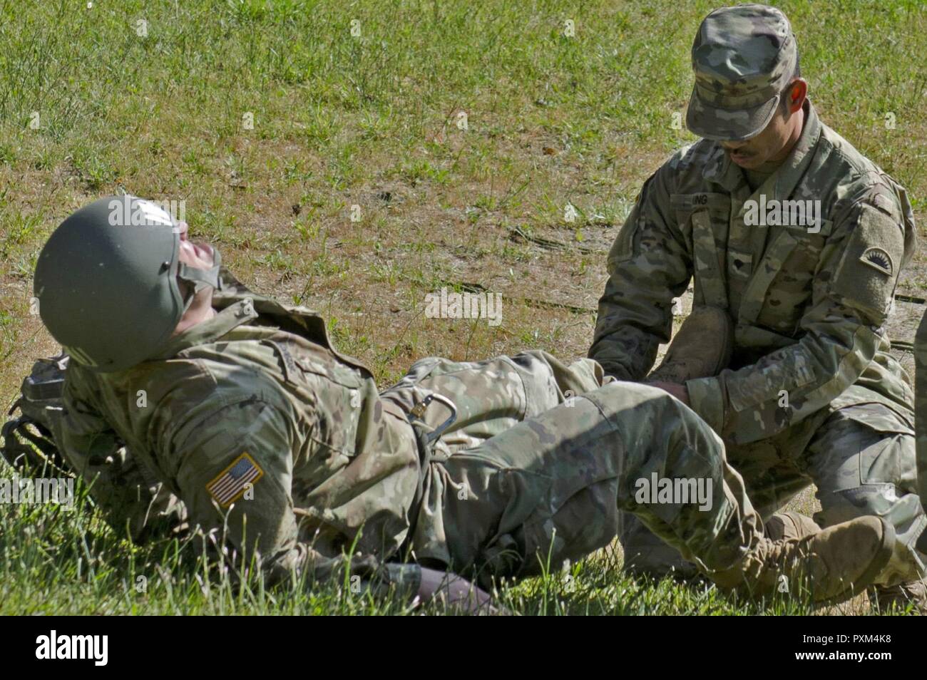 Oklahoma Army National Guard SPC. Thomas König, ein Medic zu Unternehmen, 1 Battalion, 186Th Infantry Regiment, 41st Infantry Brigade Combat Team zugewiesen ist, stellt die erste Überprüfung auf Verletzung eines Soldaten während der Air Assault Kurs am Lager Rilea in Warrenton, Virginia, 6. Juni 2017 statt. King's geholfen hat der Soldat im Air Assault praktische Übungen fort, nach Auslösung in einem Loch und Verstauchungen seinen Knöchel. Der König war ein Teil des medizinischen Teams, die die Air Assault und Pathfinder Kurse. Stockfoto