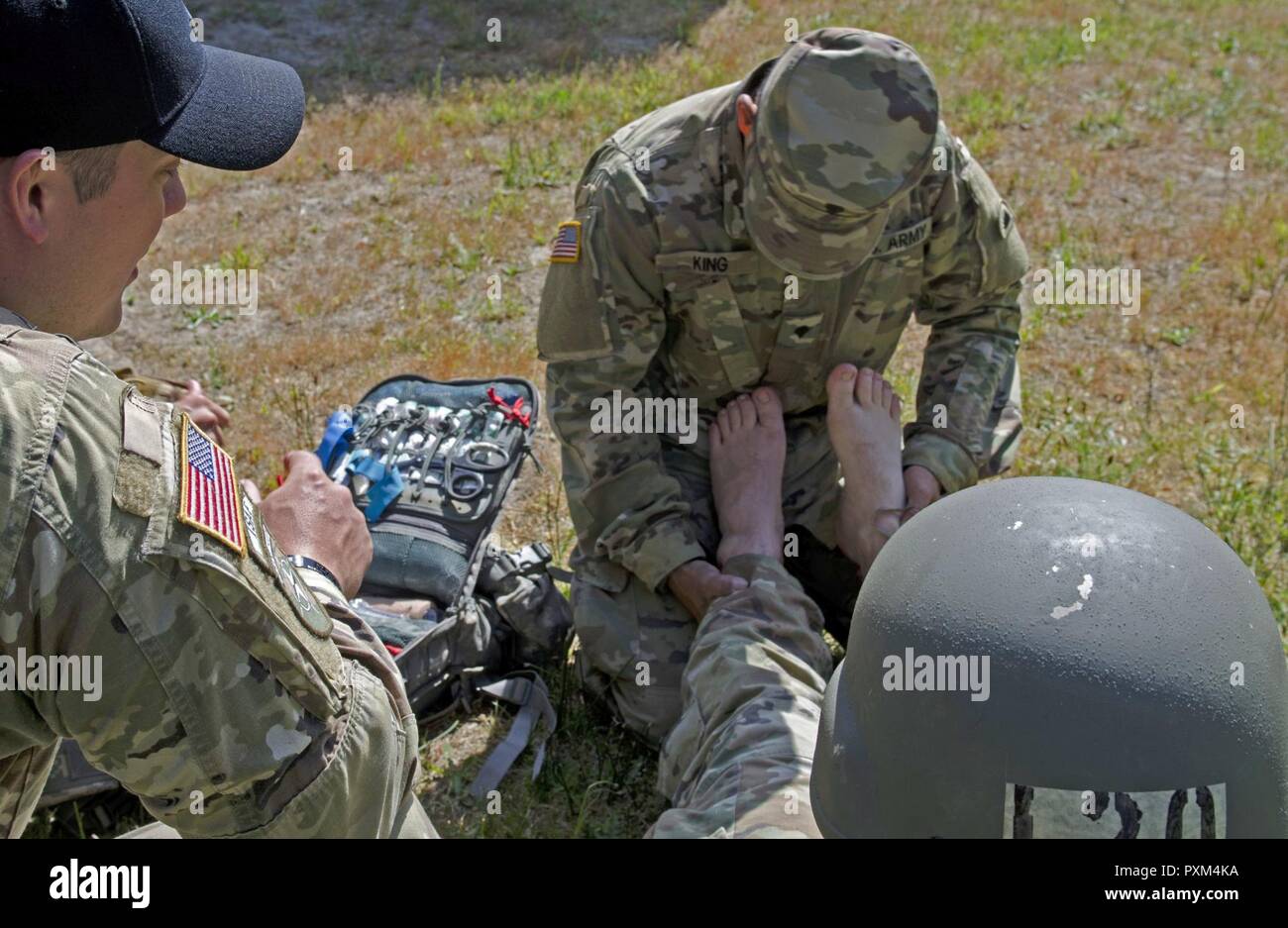 Oklahoma Army National Guard SPC. Thomas König, ein Medic zu Unternehmen, 1 Battalion, 186Th Infantry Regiment, 41st Infantry Brigade Combat Team zugewiesen ist, stellt die erste Überprüfung auf Verletzung eines Soldaten während der Air Assault Kurs am Lager Rilea in Warrenton, Virginia, 6. Juni 2017 statt. King's geholfen hat der Soldat im Air Assault praktische Übungen fort, nach Auslösung in einem Loch und Verstauchungen seinen Knöchel. Der König war ein Teil des medizinischen Teams, die die Air Assault und Pathfinder Kurse. Stockfoto