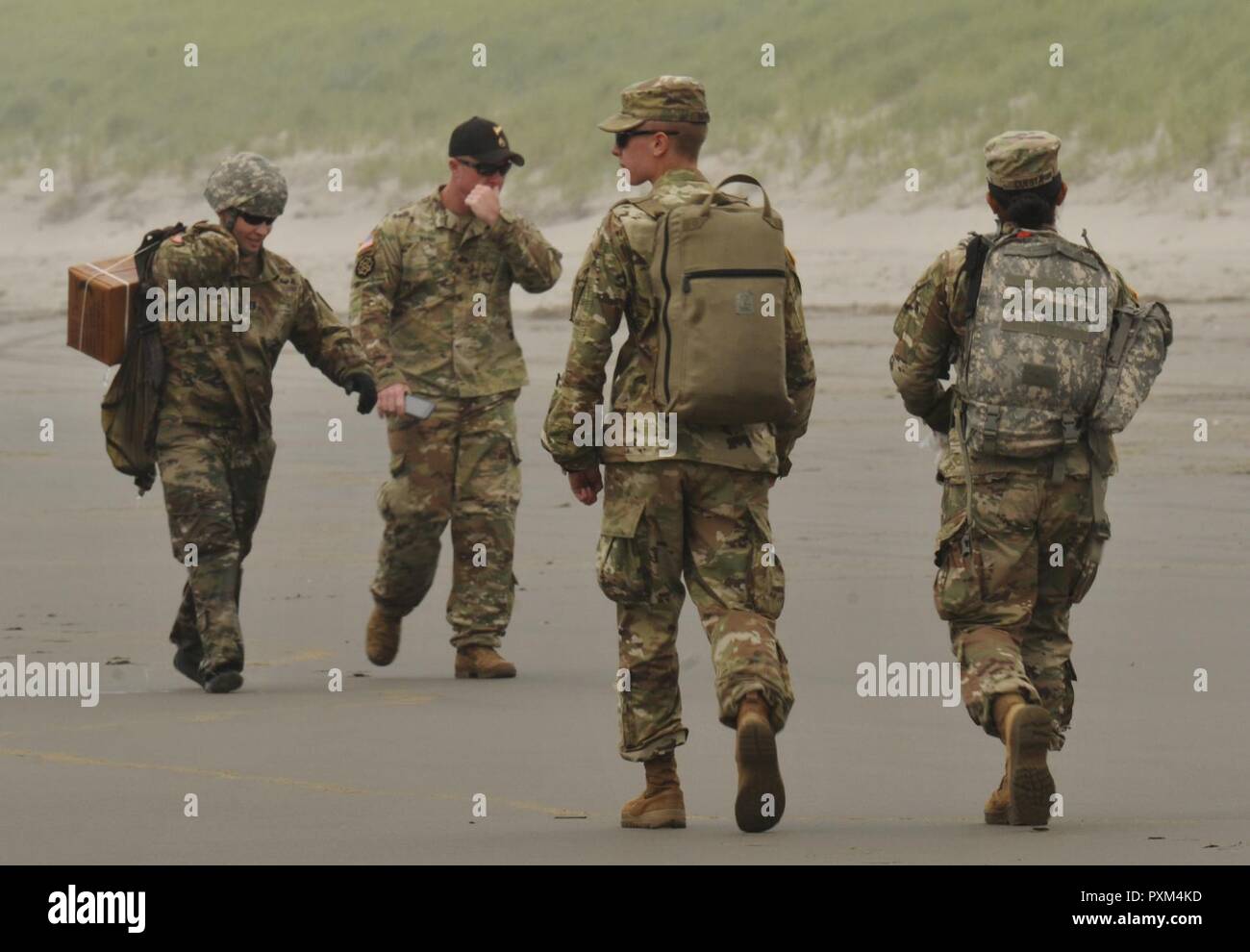 Oregon National Guard SPC. Matthäus Bringman, ein Medic mit C Unternehmen, 141 Brigade Support Bataillons, 41st Infantry Brigade Combat Team und Pfc. Elizabeth Cuesta, ein Arzt mit der Sitz und die Hauptverwaltung Loslösung, 1249Th Ingenieure Battalion, 82nd Brigade, treffen Sie Kapitän Chris Basset, ein Lager Umatilla Regional Training Institut Manager 2 Bataillon zugeordnet, 641St Aviation Regiment, und ein Pathfinder Ausbilder, wie sie wieder abrufen kann ein Paket, das in den Pazifischen Ozean im Camp Rilea in Warrenton, Virginia, 7. Juni 2017 gelandet. Basset koordiniert ein Tropfen mit einem UH-60 Black Hawk helico Stockfoto