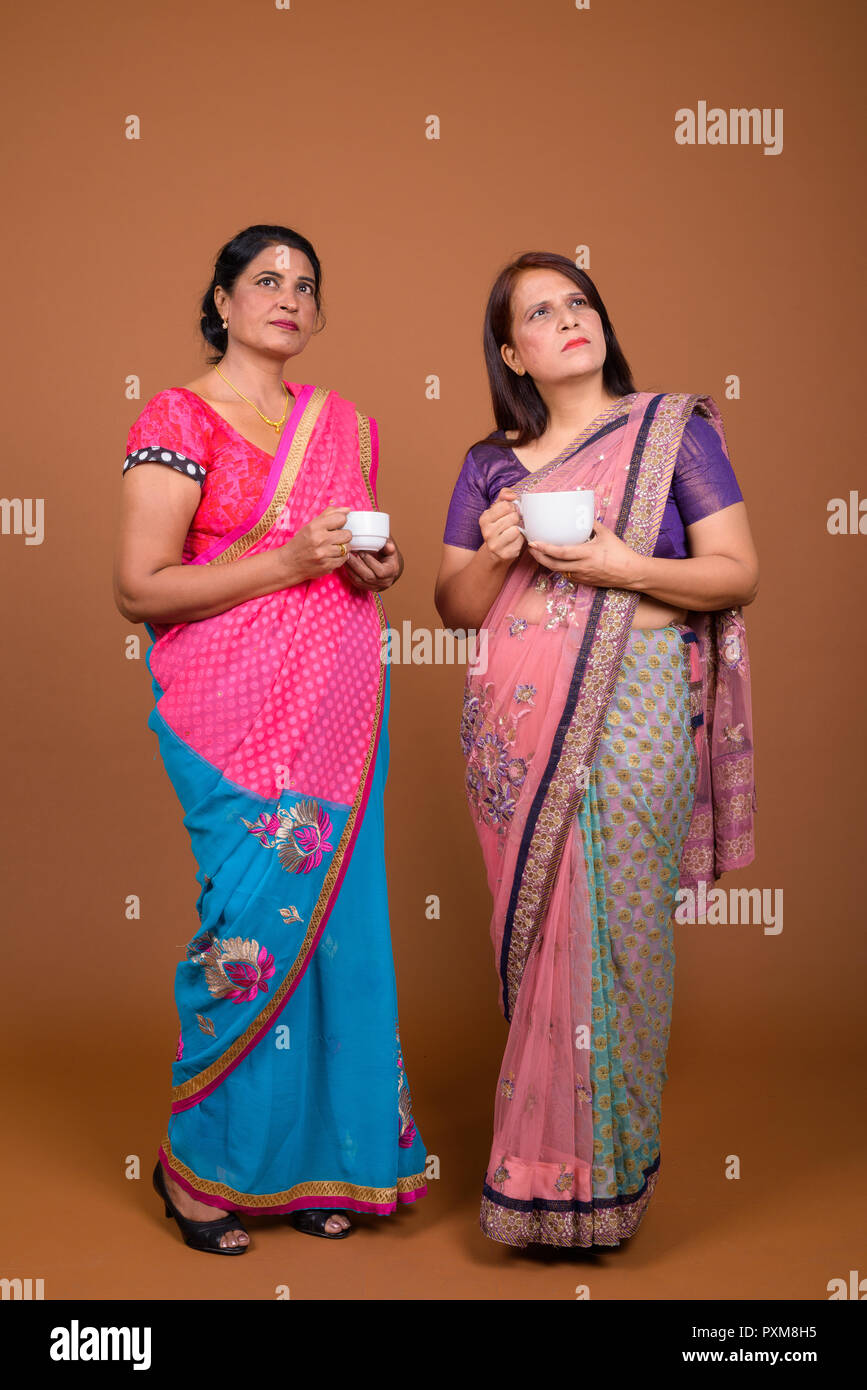 Zwei reife indische Frauen holding Kaffee oder Tee Tasse Stockfoto