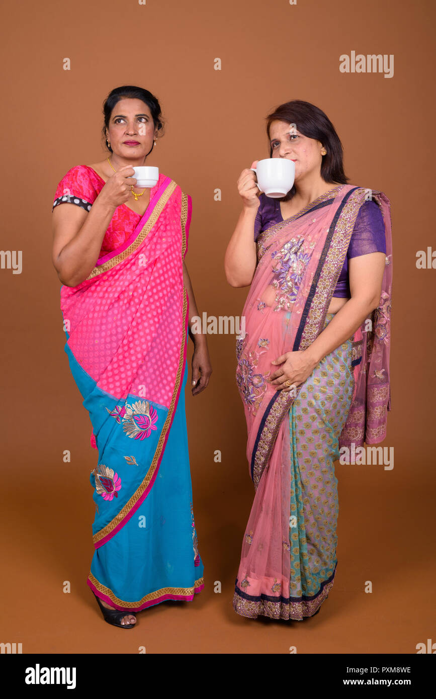 Zwei reife indische Frauen trinken Kaffee oder Tee Stockfoto