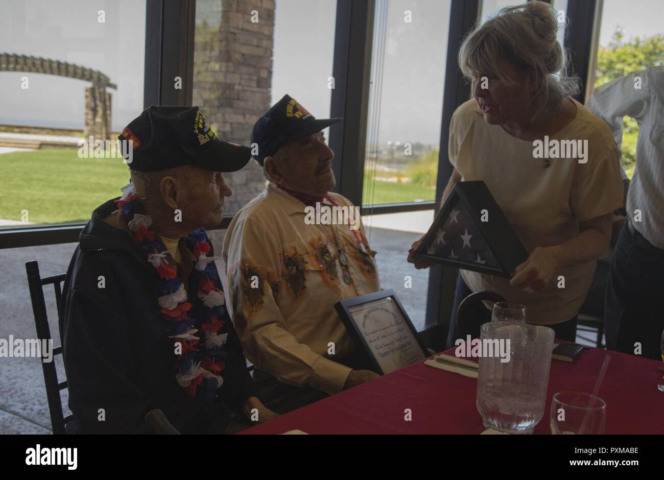 Laura Dietz, rechts, stellt Mike Mervosh, Links, mit einem Geschenk bei seinem 93. Geburtstag Feier am Pacific Views Event Center in Camp Pendleton, Kalifornien, 14. Juni 2017. Mike Mervosh, besser bekannt als Iron Mike, ist für seine 35 Jahre Dienst während des Zweiten Weltkrieges 2 anerkannt, der Koreakrieg, der Vietnamkrieg. Er ist auch ein drei - Zeit Purple Heart Empfänger. Stockfoto