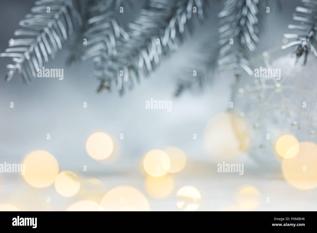 Weihnachten Silberner Hintergrund mit unscharfen Tannenbaum, Zweige und Defokussierten Girlande lichter Flecken Stockfoto
