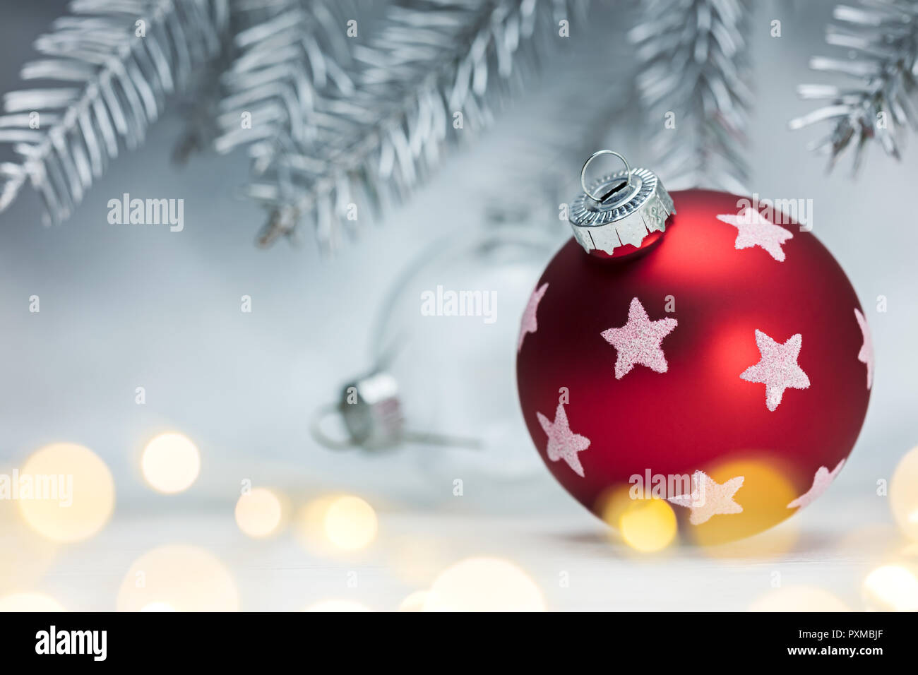 Rot dekorativer Weihnachtsbaum Kugel auf unscharfen Silberner Hintergrund mit leuchtet. Winterurlaub Konzept Stockfoto