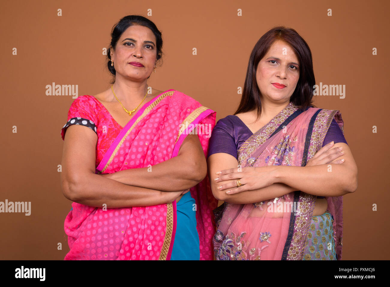 Zwei zuversichtlich Reifen indischen Frauen mit gekreuzten Armen Stockfoto