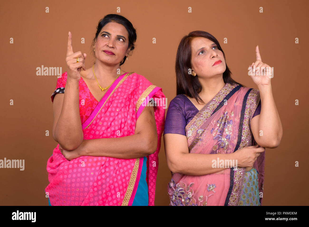 Zwei reife indische Frau denken und zeigt mit dem Finger auf Stockfoto