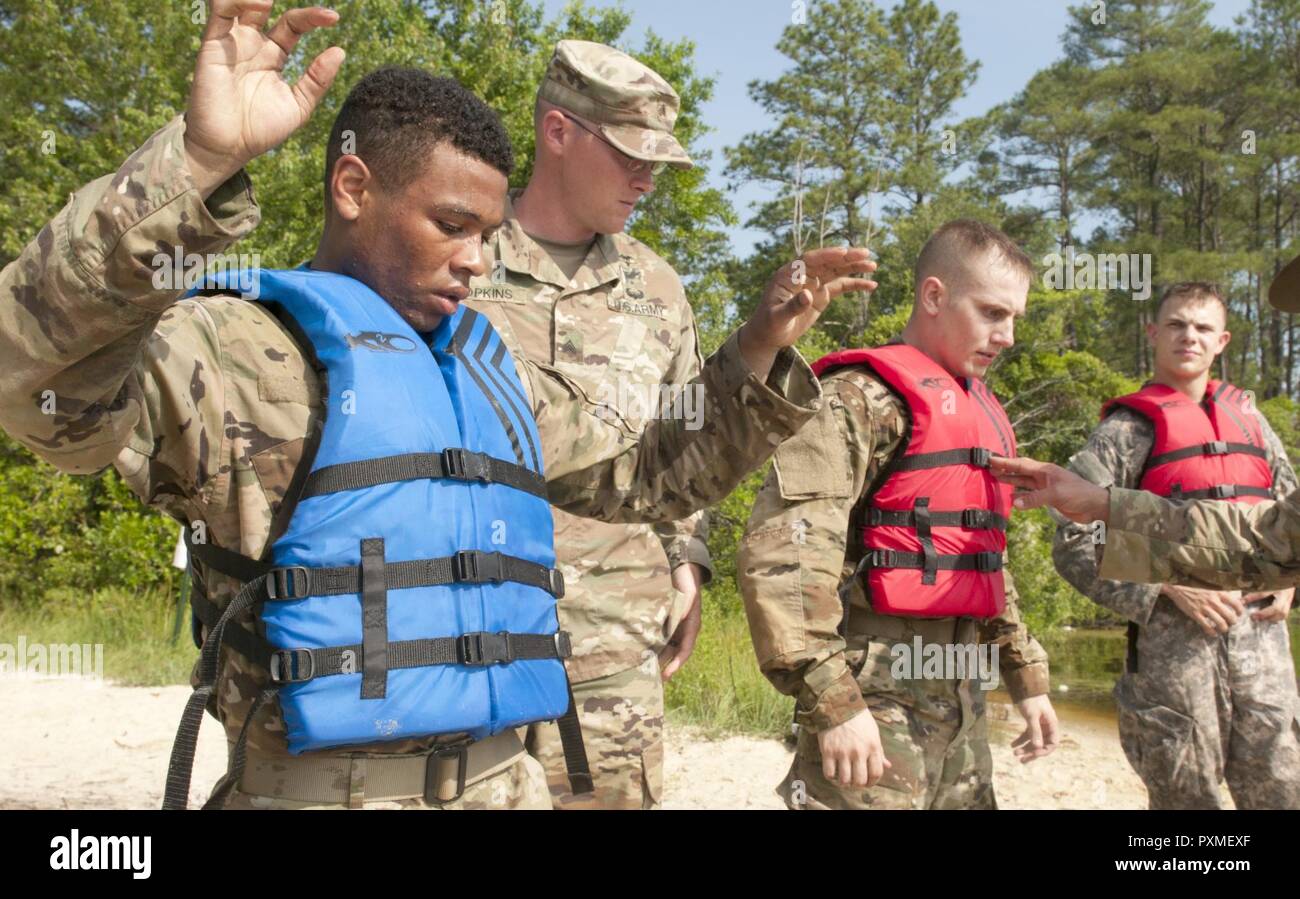 Pfc. Andrew Grün (links), eine Armee rechtsassistent als Vertreter der Armee finden Rechtliche Befehl, gehört zu einer Gruppe von Kriegern Vorbereitung mit Gewehren über eine 300 Meter zu schwimmen See als Teil der US-Army Reserve 2017 besten Krieger Wettbewerb in Fort Bragg, N.C. Juni 15. In diesem Jahr besten Krieger Wettbewerb bestimmen die oberen noncommissioned Officer und Junior Soldat Soldat der US-Armee finden in der Abteilung der Armee am besten Krieger Konkurrenz später dieses Jahr vertreten wird am Fort A.P. Hill, Virginia. Stockfoto