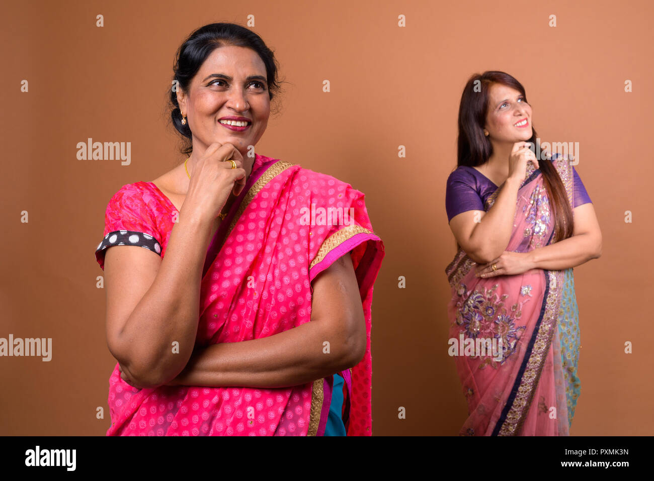 Zwei glückliche indische Frau denken und lächelnd Stockfoto