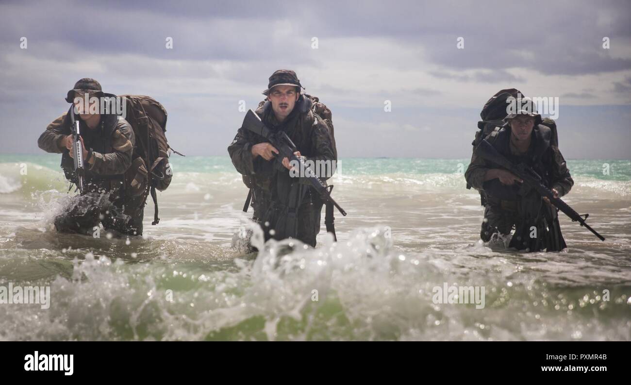 MARINE CORPS TRAINING BEREICH FALTENBALG - Lance Cpl. Shane Springstead, Cpl. Ryan Ehlers, und Lance Cpl. Armanie Singletary, Radio Reconnaissance team Betreiber mit Radio Reconnaissance Platoon, 3 Radio Bataillon bereiten Sie den Strand von Kraft während der Funkaufklärung Operator Kurs an Bord Marine Corps Training Bereich Faltenbalg, 15. Juni 2017. Das Ufer zu erreichen, hatte Marines eine zwei Kilometer zu Schwimmen mit mehr als 65 Pfund. Stockfoto