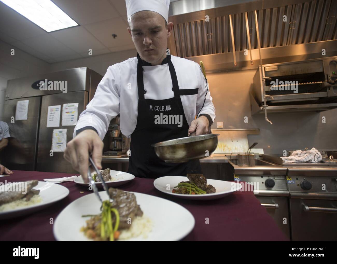 MANAMA, Bahrain (16. Juni 2017) Kulinarische Specialist 2. Klasse Michael Colburn, ein sous Chef Trainee aus Neapel, Fla., Platten sein letztes Gericht innerhalb der US Naval Forces Central Command (NAVCENT) Sitz Flagge Durcheinander onboard Naval Support Activity Bahrain, Juni 16. Colburn bestanden die amerikanischen kulinarischen Vereinigung Certification Test seine Expertise in der kulinarischen Künste dieser Skill der NAVCENT Commander mit Ziel und das Erreichen gemeinsamer Ziele mit Führer in der Region, indem sie ihnen zu einem attraktiven und ansprechenden Mahlzeit zu sitzen Aids weiter. Stockfoto