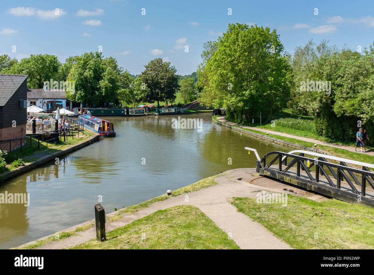 Canal narrowboats günstig am unteren Becken an Foxton Locks, zusammen mit Menschen genießen die Sonne kann außerhalb der Foxton Locks Canal Side Inn. Stockfoto