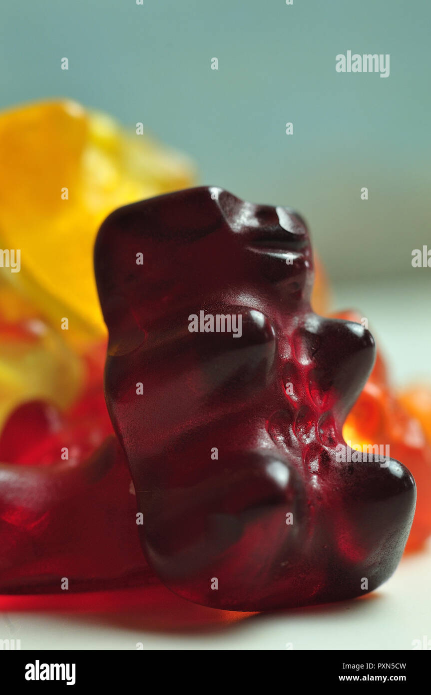 Makrofotografie eines roten Gummibärchen lehnte sich gegen einen Haufen der Fruchtgummi Bonbons Stockfoto