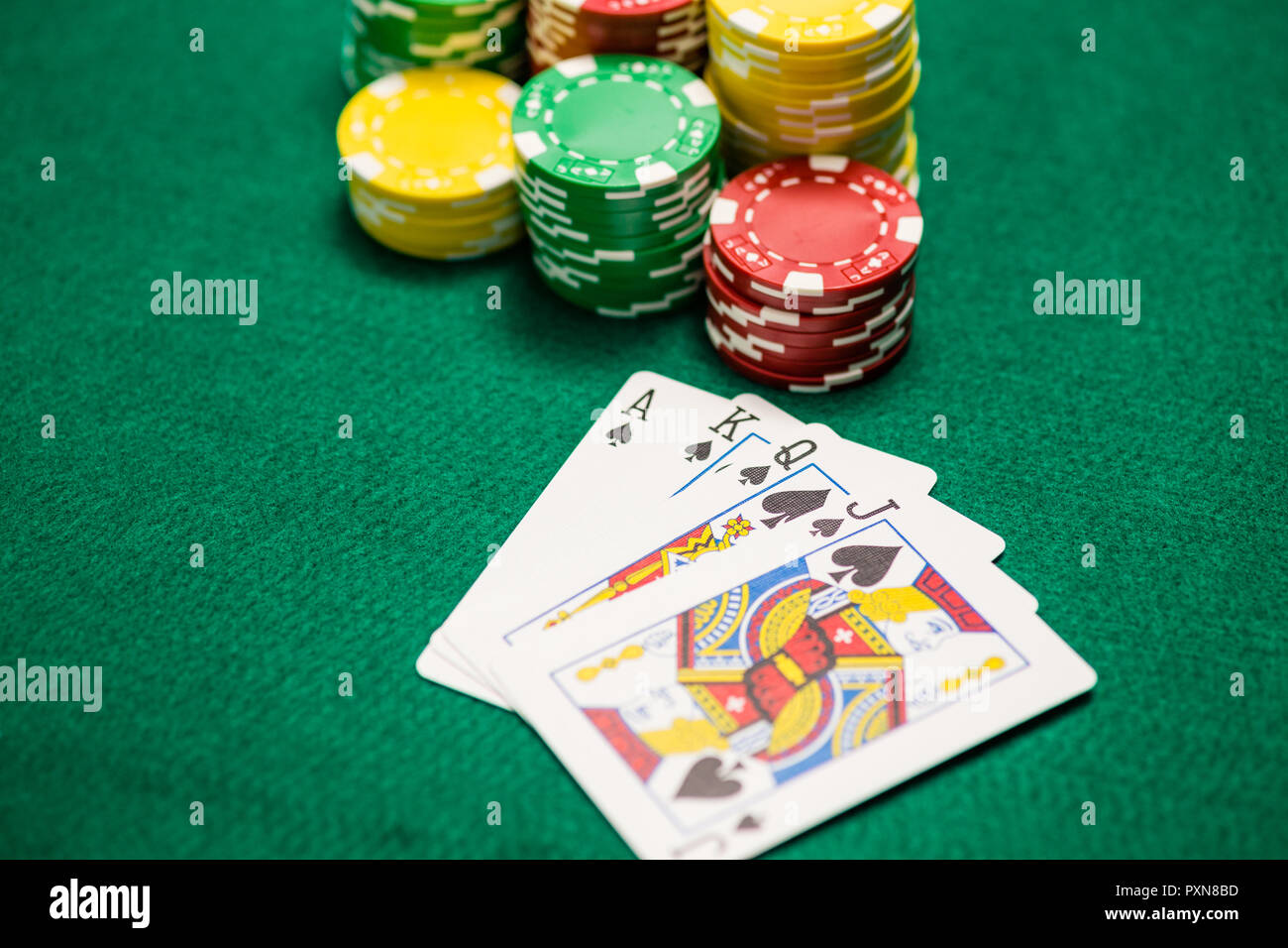 Casino Chips und Ass, König Königin pikbube am grünen Tisch Stockfoto