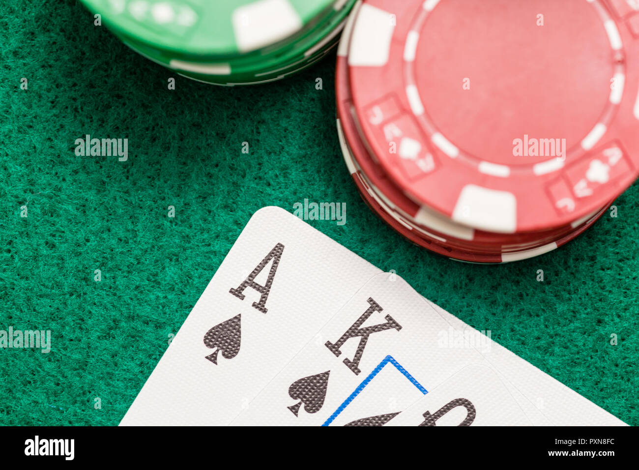Casino Chips und Ass, König, Pik Dame am grünen Tisch Stockfoto