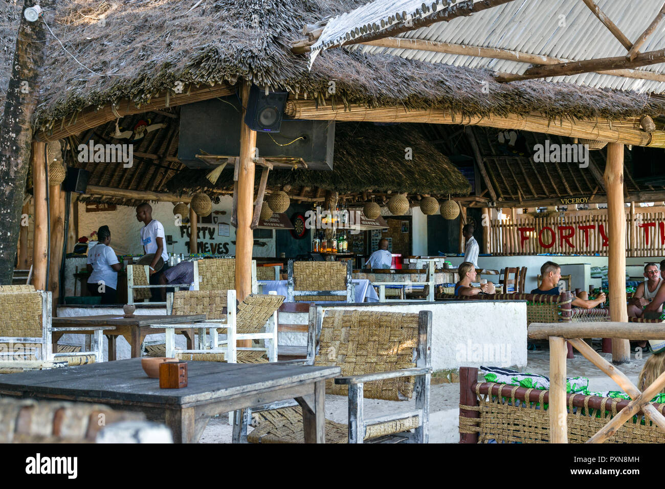 Die berühmten Forty Thieves Bar und Restaurant mit Touristen setzte sich an die Bar, Diani, Kenia Stockfoto