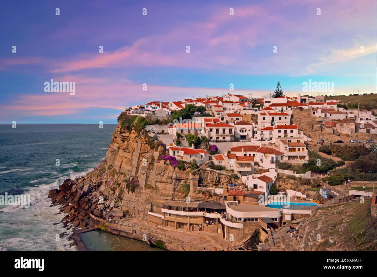 Traditionelle portugiesische Dorf auf einer Klippe mit Blick auf den Ozean in Azenhas De Mar, Portugal bei Sonnenuntergang Stockfoto