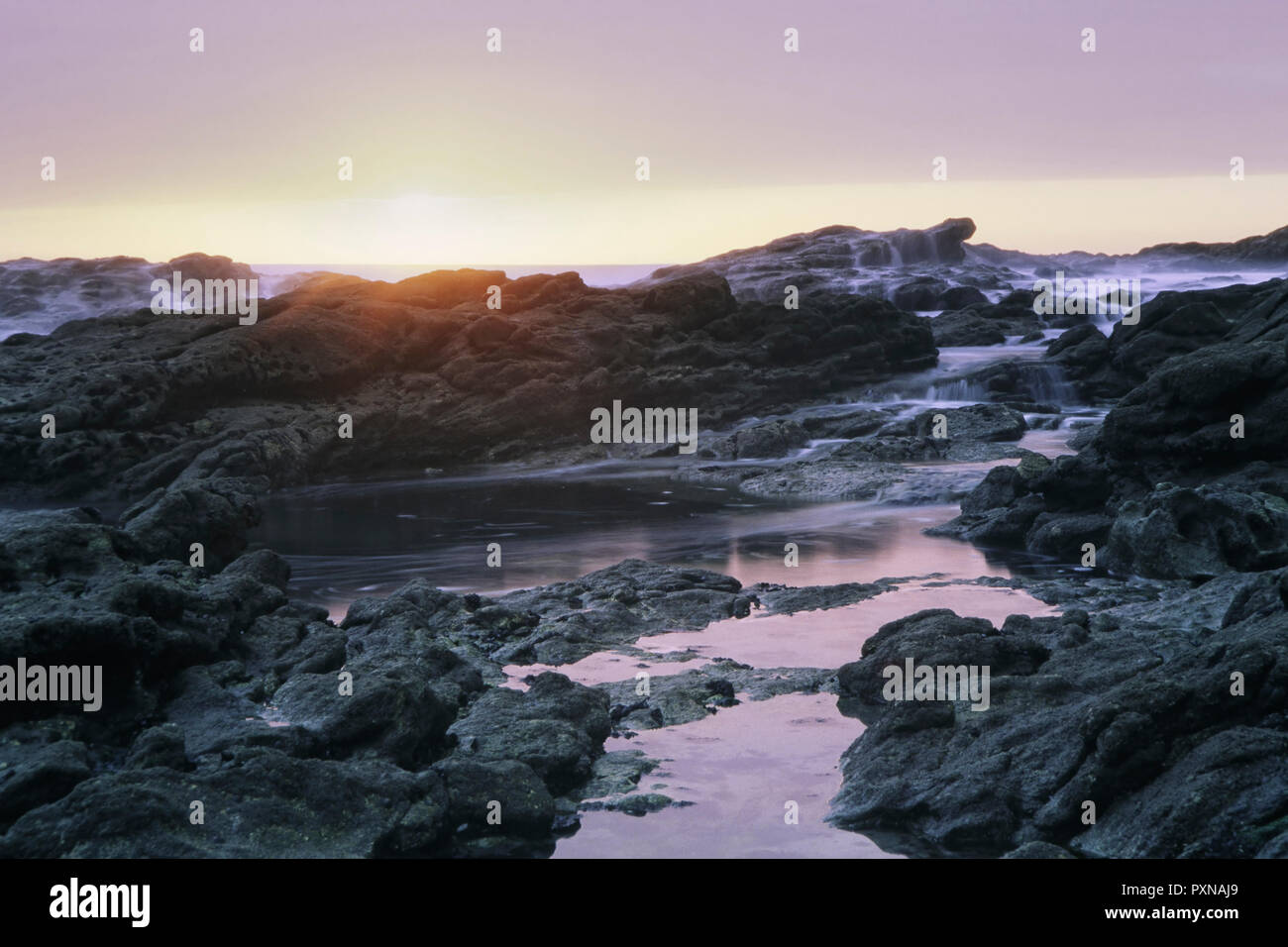 Lange Belichtung in einem portugiesischen felsigen Strand bei Sonnenuntergang. Analog: 35-mm-Dia Film. Stockfoto