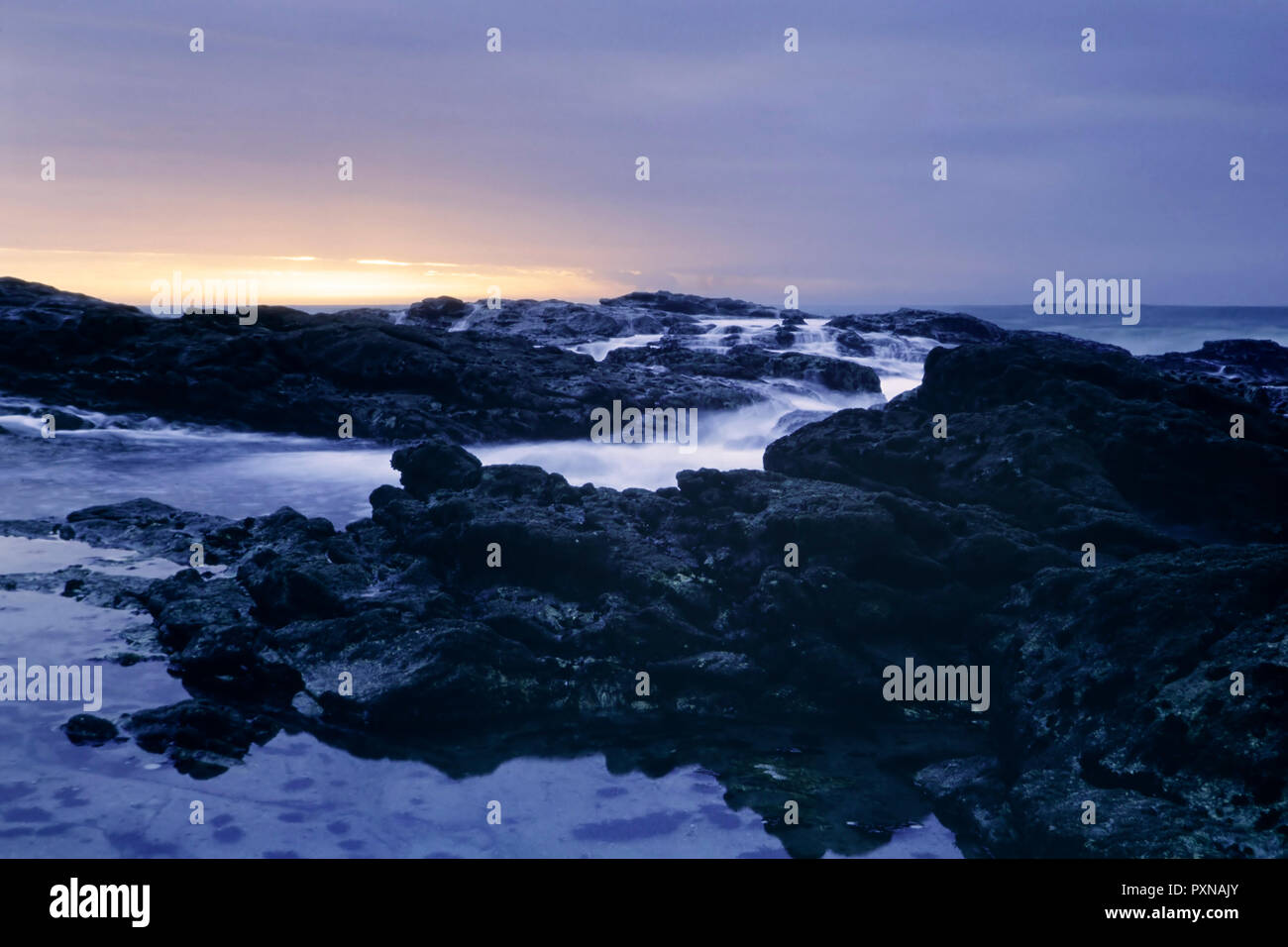 Lange Belichtung in einem portugiesischen felsigen Strand in der Abenddämmerung. Analog: 35-mm-Dia Film. Stockfoto