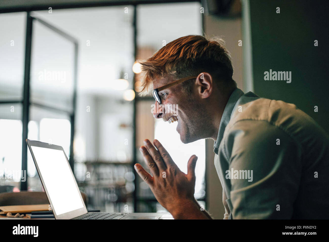 Junger Mann mit Laptop, Lachen happly Stockfoto