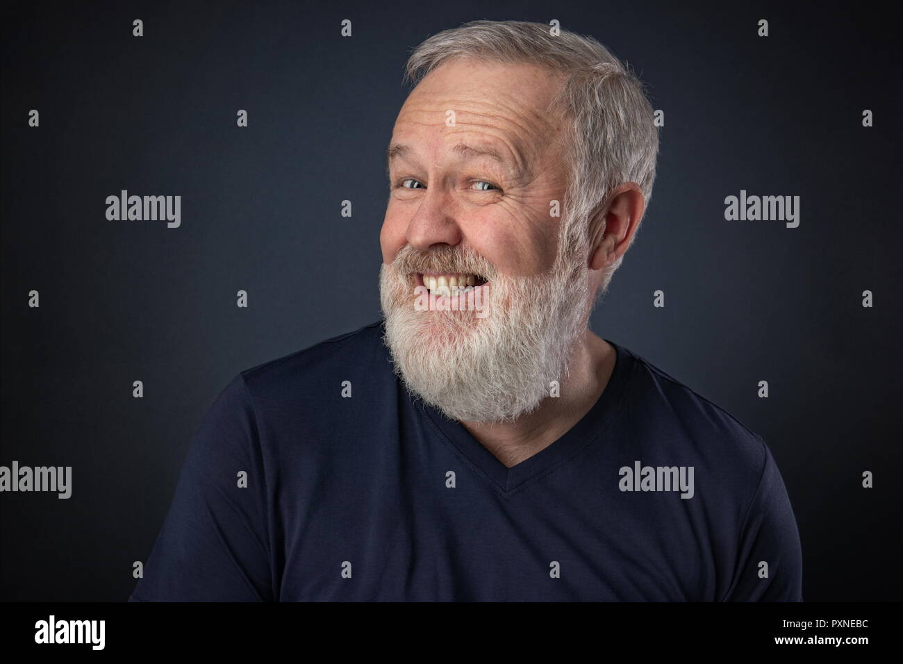 Alter Mann Porträt mit grauen Bart auf blauem Hintergrund spielen und vorgibt, zu lachen. Stockfoto