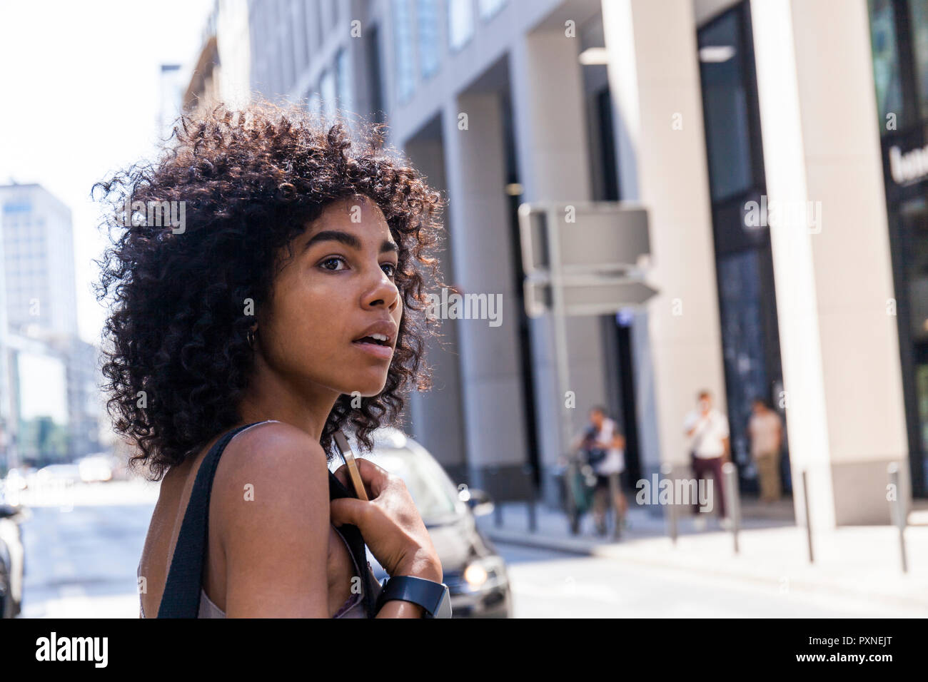 Deutschland, Frankfurt, Porträt der jungen Frau mit dem lockigen Haar in der Stadt Stockfoto