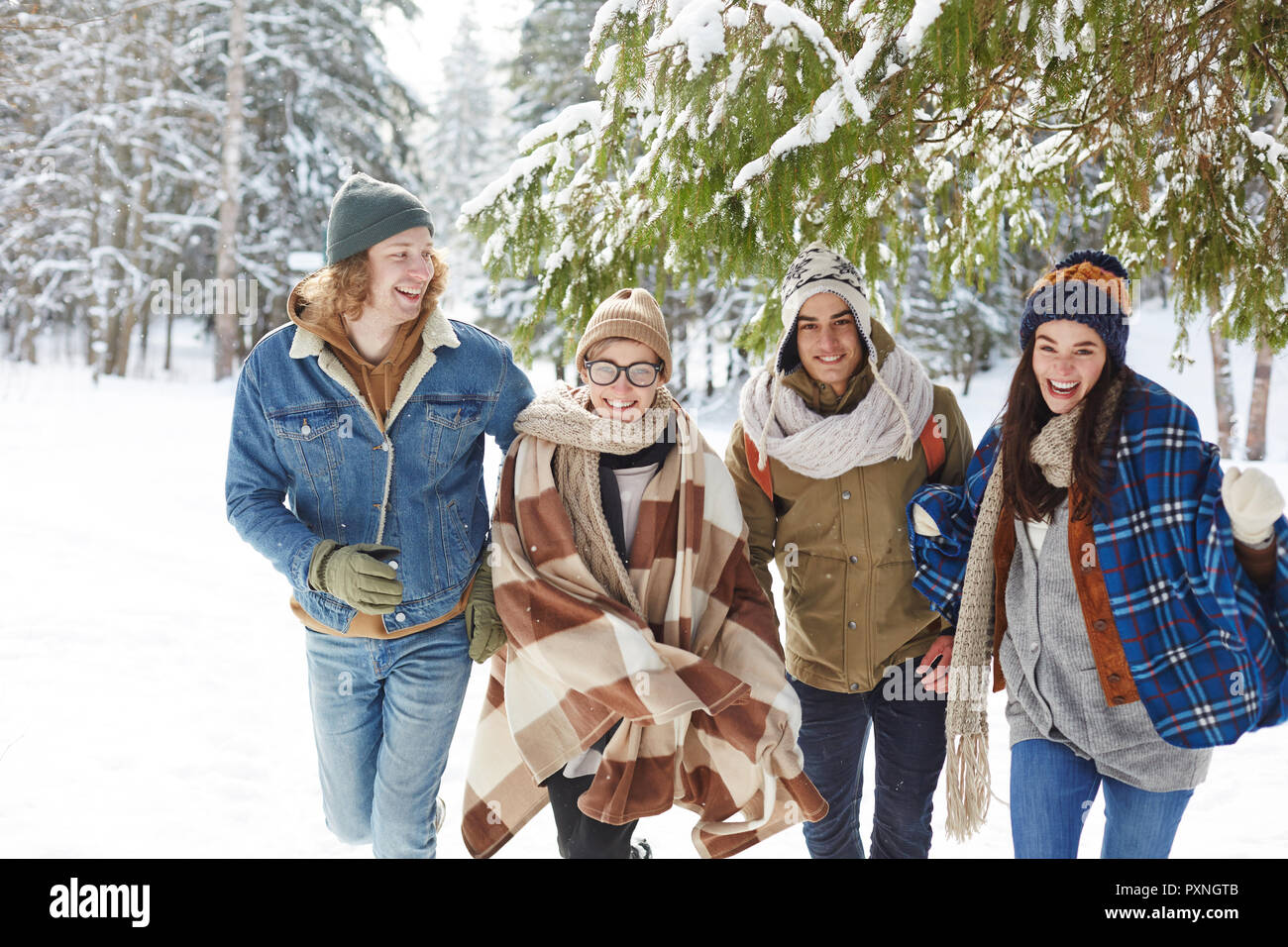 Gruppe von Jugendlichen in Richtung Kamera im Winter Forest und glücklich lachend Zeit im Urlaub Stockfoto