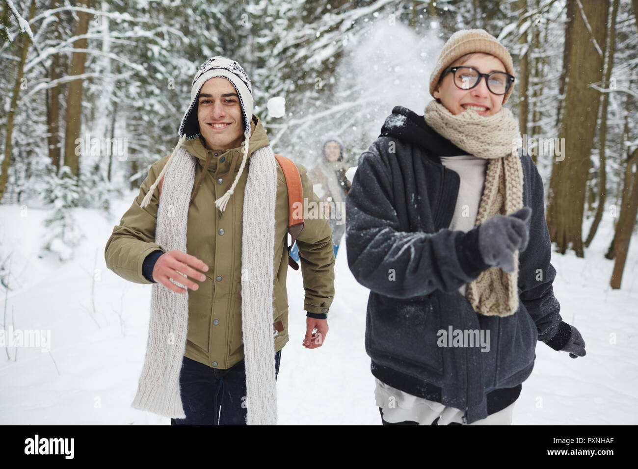 Portrait von glückliches junges Paar, das Spaß im Winter Wald und laufen in Richtung Kamera während der Ferien Stockfoto