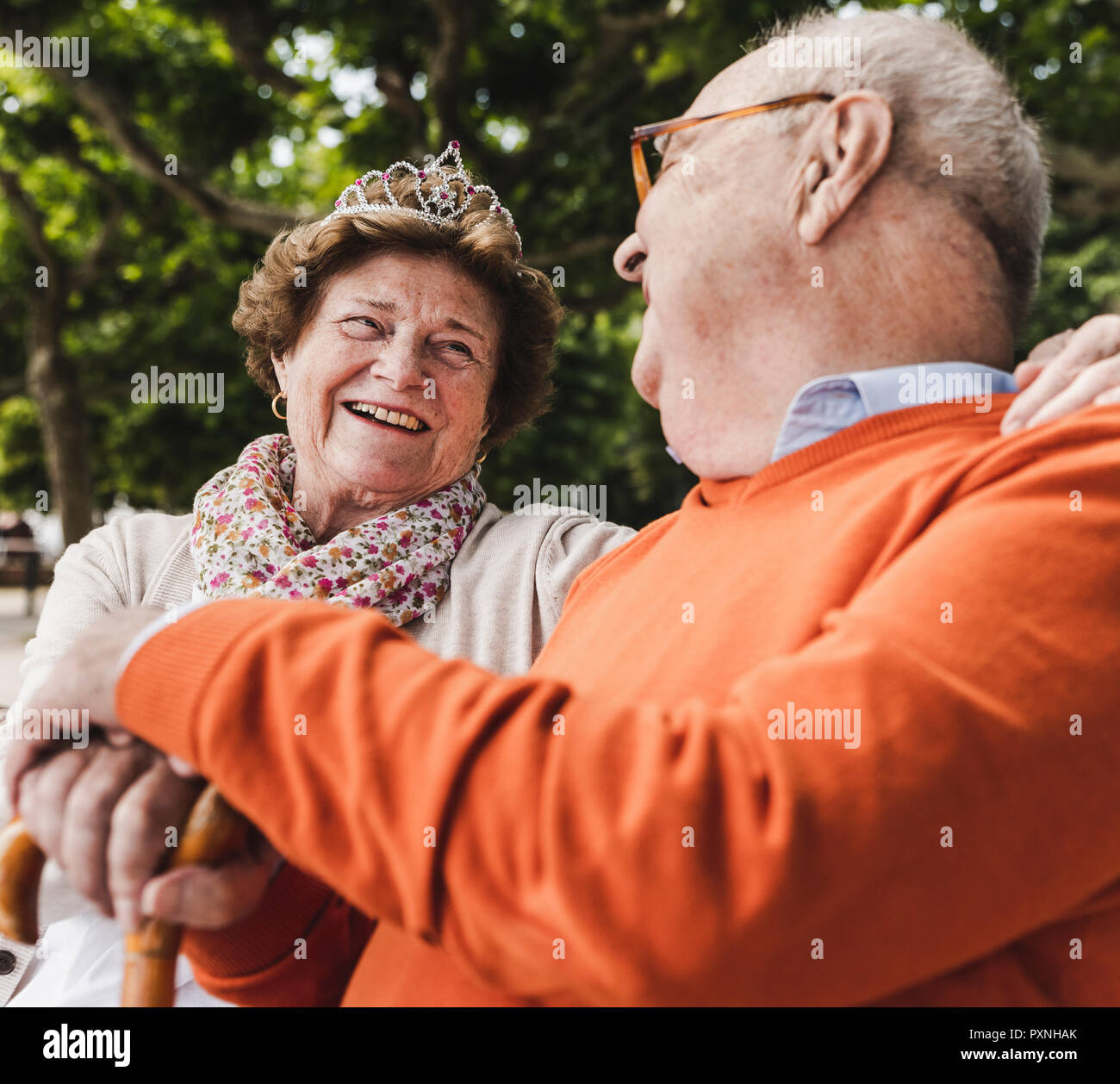 Gerne älteres Paar im Park sitzen, Frau Krone tragen Stockfoto