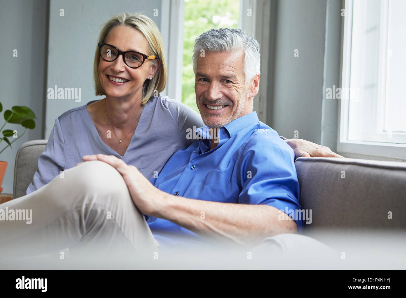 Portrait von lächelnden Reifes Paar auf der Couch zu Hause Stockfoto