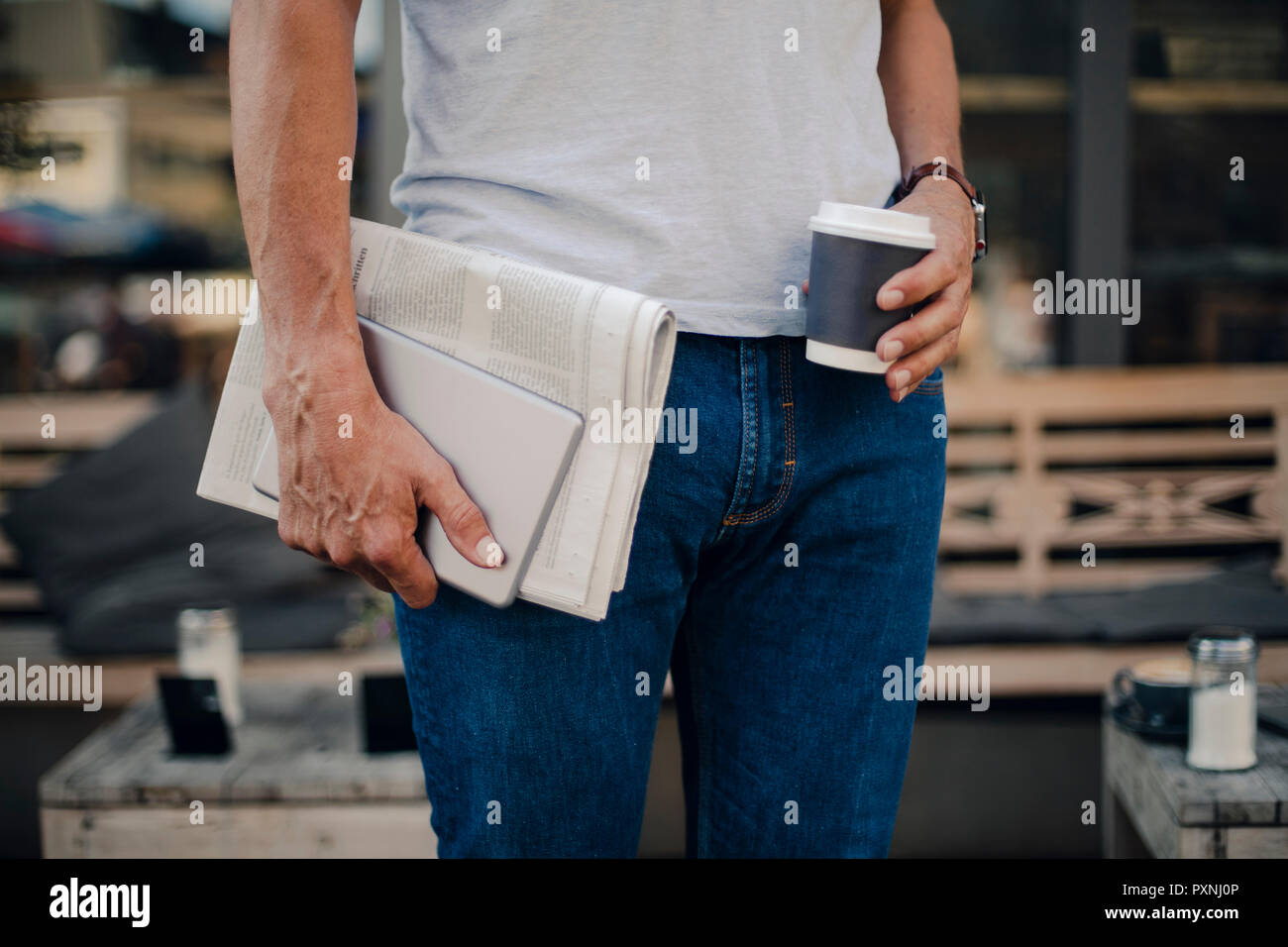 Reifen Mann mit Zeitung, digitale Tablet und einer Tasse Kaffee, mittlerer Abschnitt Stockfoto