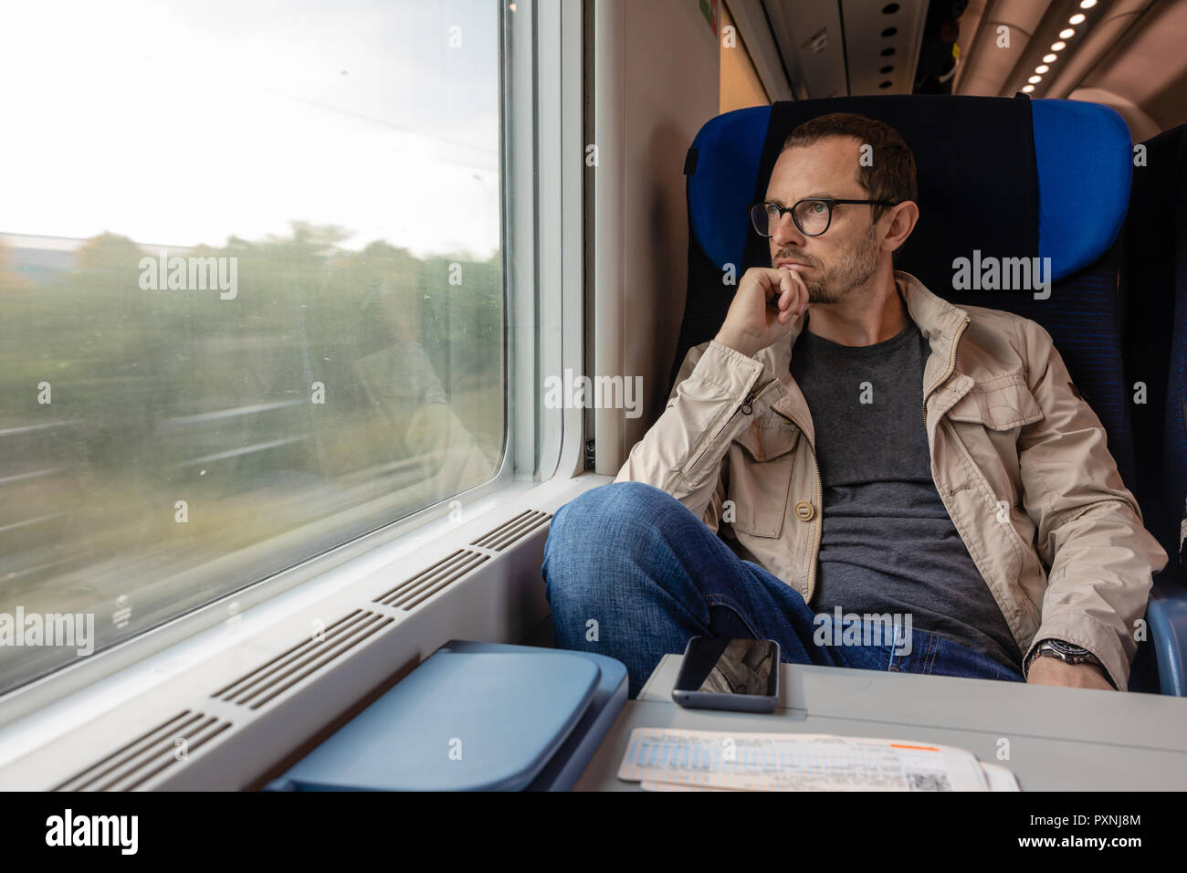 Mittleres alter Mann schaut aus dem Fenster der Bahn. Passagier während der Reise durch hohe Geschwindigkeit Express Zug, Europa Stockfoto