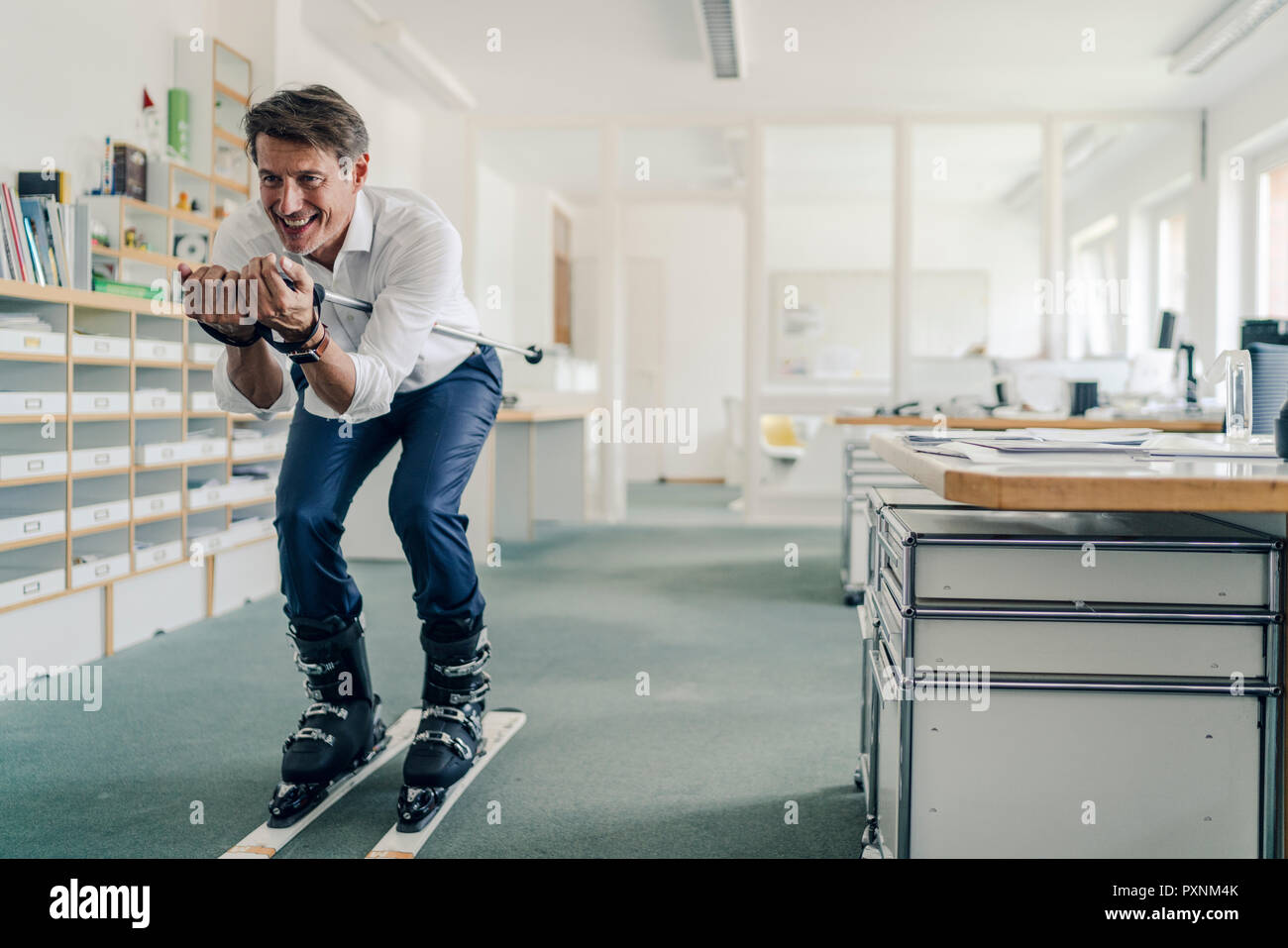 Geschäftsmann Skifahren im Büro Stockfoto