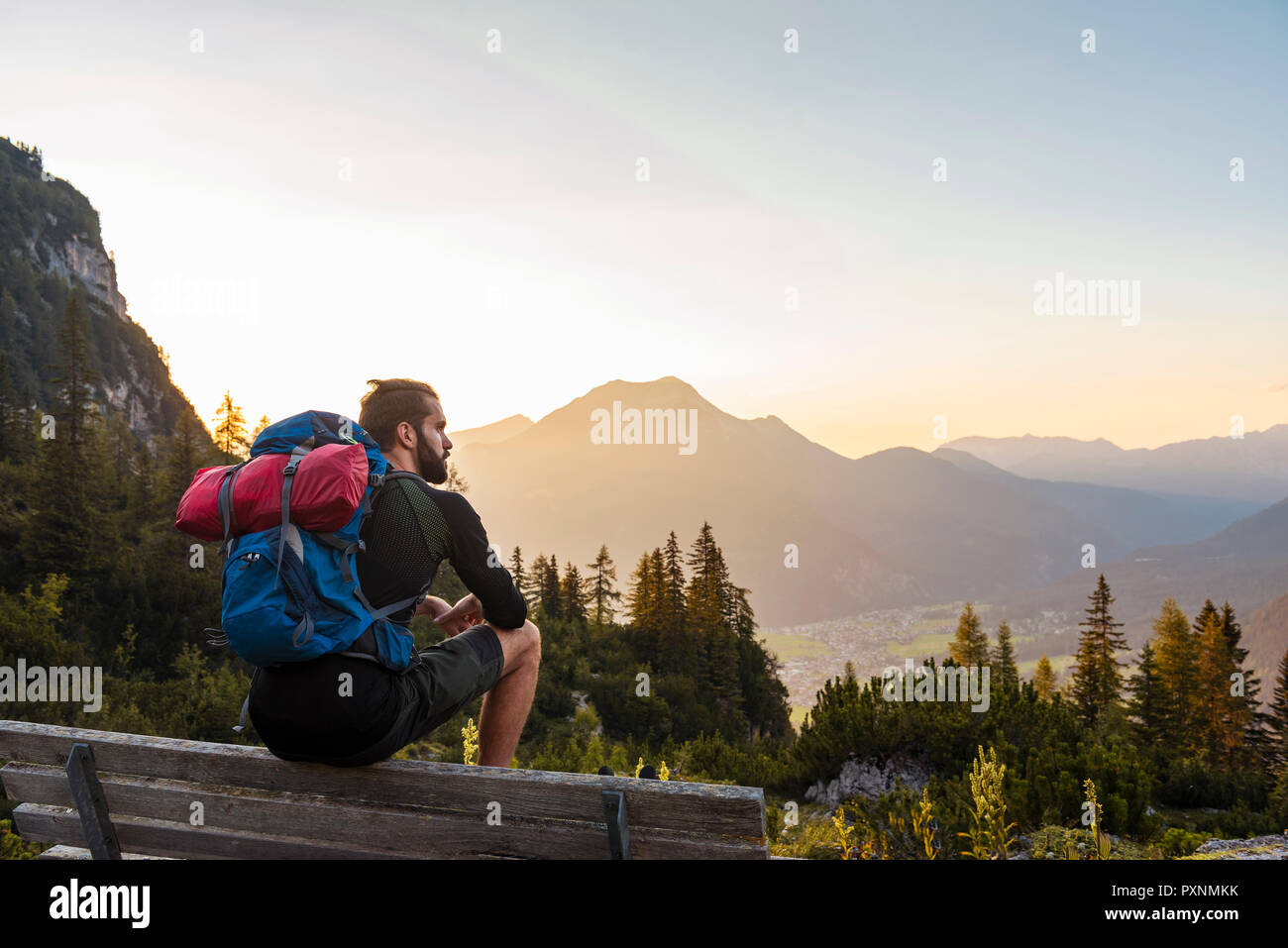 Österreich, Tirol, Wanderer eine Pause, sitzt auf der Bank, auf der Suche nach Anzeigen Stockfoto